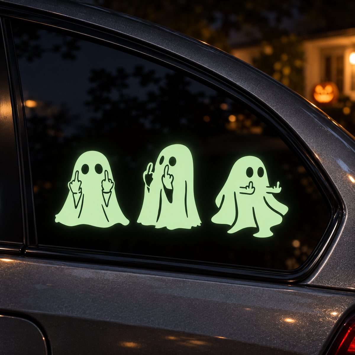 Three ghost car window decals glowing green in the dark