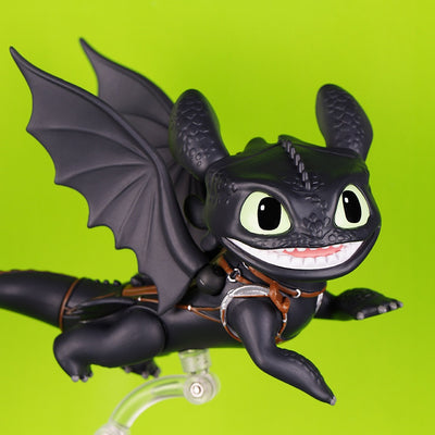 Black articulated Toothless figure in a flying pose on a clear display stand