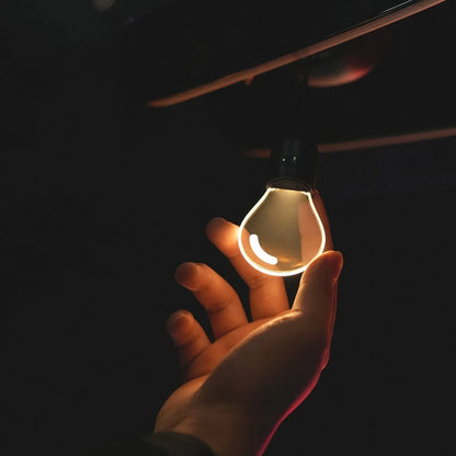 CARMOJ Glowing light bulb car charm illuminated in a hand