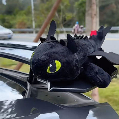 Black plush Toothless ornament secured at an open car sunroof with wings extended