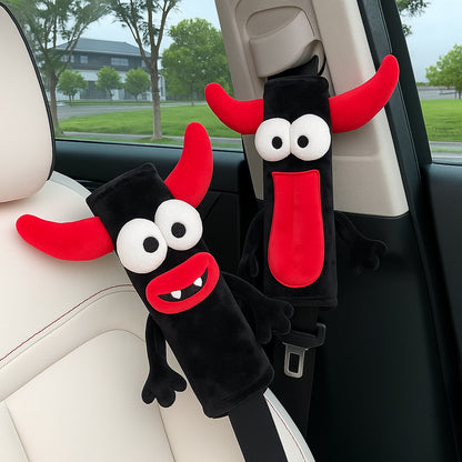 CARMOJ Two demon plush seat belt shoulder pads installed inside a car